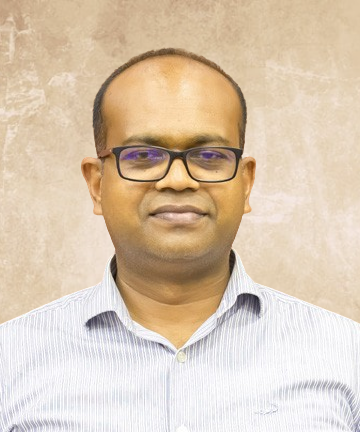 Portrait of a man wearing rectangular glasses and a light striped shirt, facing the camera with a neutral expression.